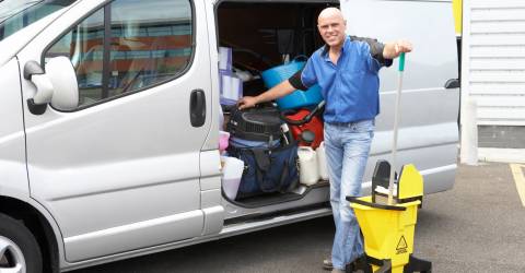 man met schoonmaakspullen voor bus